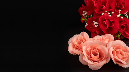 Closeup of the decorative bouquet of artificial red roses on the black background