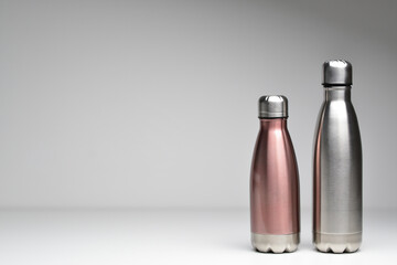 Two stainless thermos water bottle, isolated on grey background. Silver color. Steel thermo water bottle. Be plastic free. Zero waste. Copy space. Zero waste, no plastic.