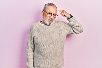 Handsome senior man with beard wearing casual sweater and glasses pointing unhappy to pimple on...