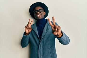 Young african american man wearing elegant style smiling looking to the camera showing fingers doing victory sign. number two.