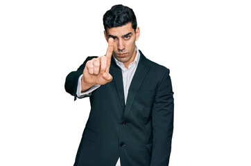 Handsome hispanic man wearing business clothes pointing with finger up and angry expression, showing no gesture