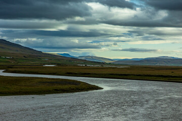 summer road trip on an open high way in Route 1 in Iceland with dramatic mountain landscape on the background.