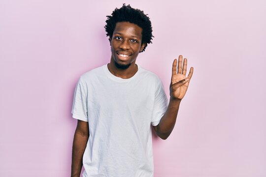 Young african american man wearing casual white t shirt showing and pointing up with fingers number four while smiling confident and happy.