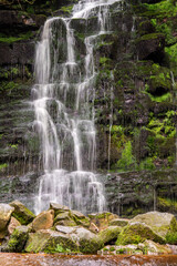 Fototapeta premium A waterfall cascading down over rocks in the Peak District