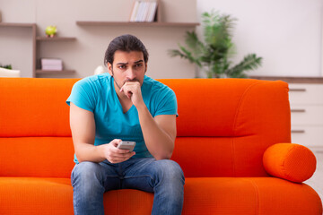 Young male student watching tv indoors