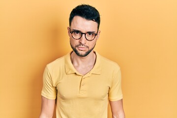 Young hispanic man wearing casual clothes and glasses skeptic and nervous, frowning upset because...