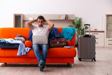 Young man student preparing for trip at home