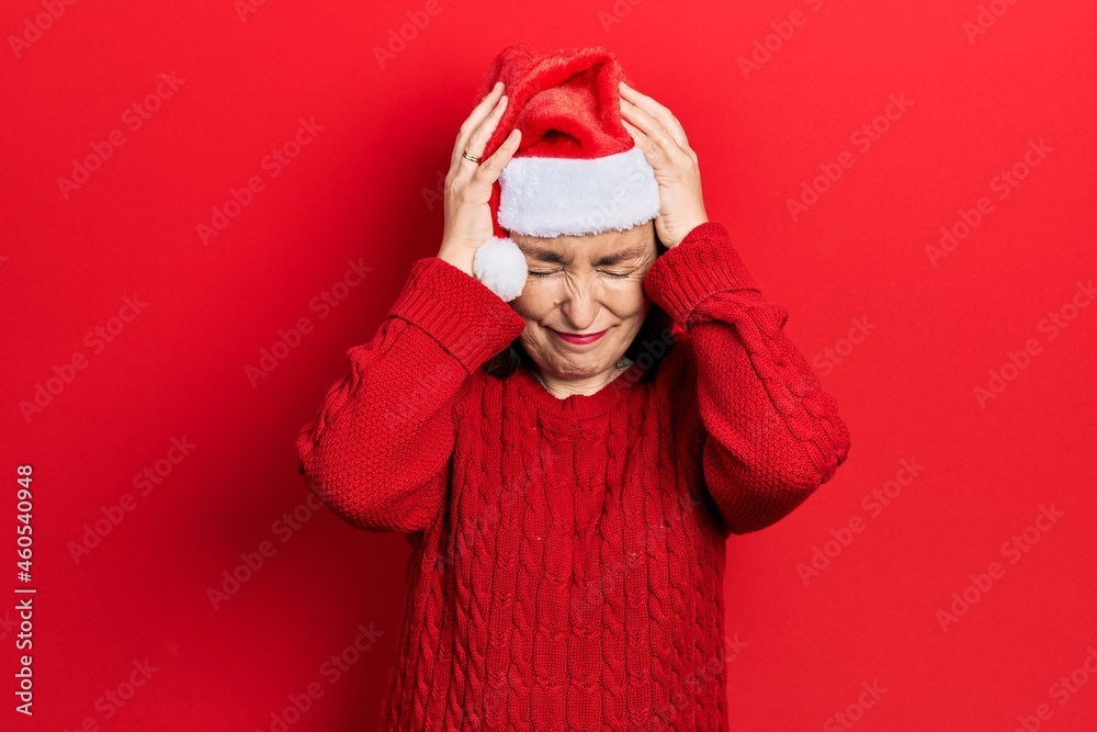 Poster Middle age hispanic woman wearing christmas hat suffering from headache desperate and stressed because pain and migraine. hands on head.