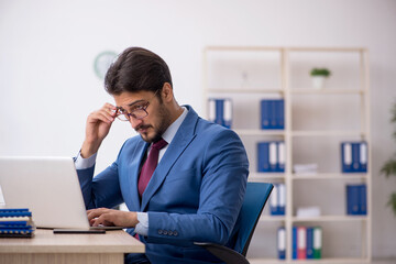 Young male employee working at workplace