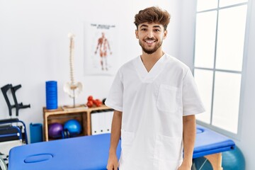 Young arab man working at pain recovery clinic with a happy and cool smile on face. lucky person.