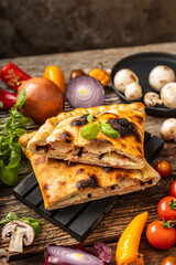 Sliced pizza calzone served on tha black palette