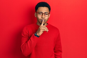 Young african american man wearing casual clothes and glasses asking to be quiet with finger on lips. silence and secret concept.
