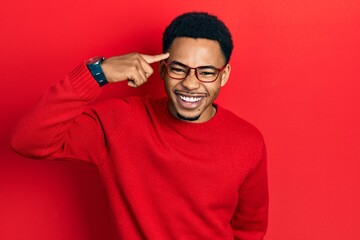 Young african american man pointing head with finger smiling and laughing hard out loud because...