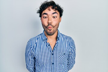 Young hispanic man wearing casual clothes making fish face with lips, crazy and comical gesture. funny expression.