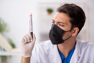 Young male biochemist testing blood samples