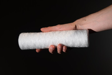 Filter for water in hand. New white filter cartridge. Filtration for drinking.