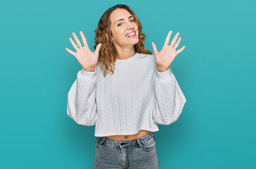 Beautiful young caucasian woman wearing casual winter sweater showing and pointing up with fingers number ten while smiling confident and happy.