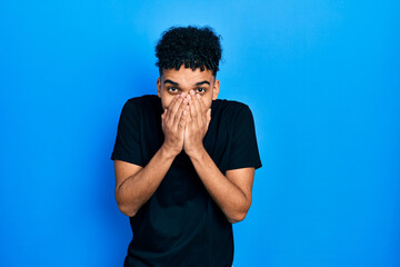 Young african american man wearing staff t shirt laughing and embarrassed giggle covering mouth...