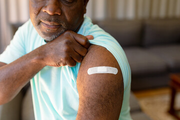 African american senior man showing plaster after vaccination
