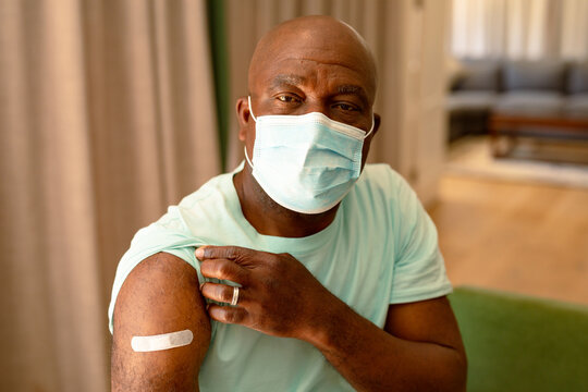 Portrait Of African American Senior Man In Face Mask Showing Plaster After Vaccination