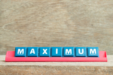 Tile alphabet letter with word maximum in red color rack on wood background