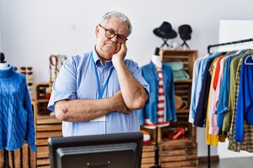 Senior man with grey hair working as manager at retail boutique thinking looking tired and bored with depression problems with crossed arms.