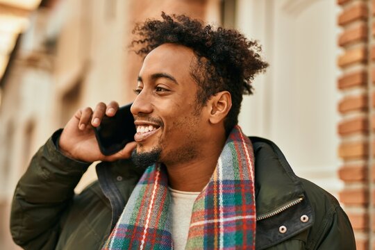 Young african american man smiling happy talking on the smartphone at the city
