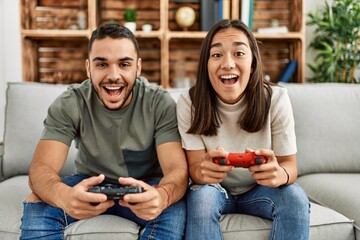 Young latin couple smiling happy playing video game at home. © Krakenimages.com