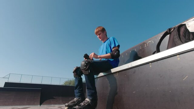 Man in protection in a skatepark on roller skates