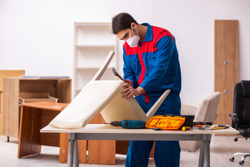 Young male carpenter working in the office during pandemic