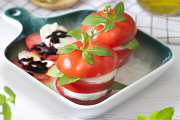 caprese canapes in a green plate. Tomatoes with mozzarella