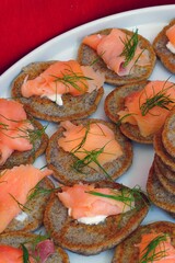 Platter of mini buckwheat blinis with smoked salmon and dill