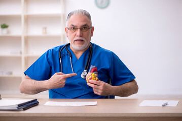 Old male doctor cardiologist working in the clinic