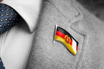 Metal badge with the flag of GDR on a suit lapel