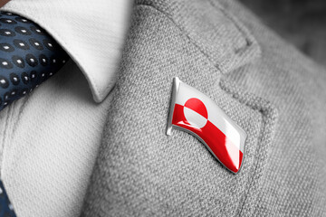 Metal badge with the flag of Greenland on a suit lapel © butenkow