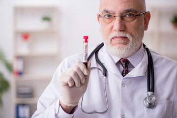 Old male doctor hematologist working in the clinic