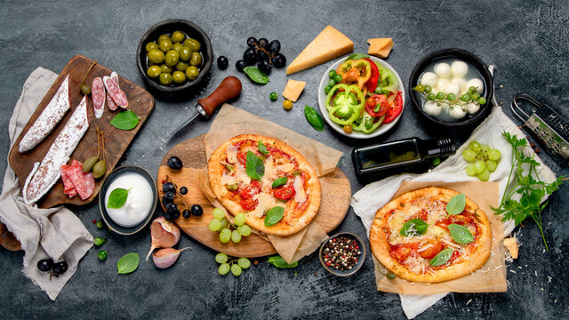 Italian food assortment on dark background.