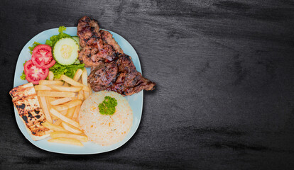 Close up of roasted chicken with gallo pinto and pico de gallo, Nicaraguan food served on slate background, Plate of roast chicken with rice and tomatoes served on slate background