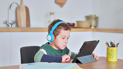 Smart boy student listen to online lesson on tablet wear headphones Spbas. Homeschooled child watch.