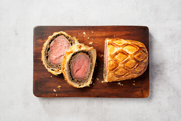 Beef Wellington - beef tenderloin festive dish. English cuisine. Light gray stone background. top...