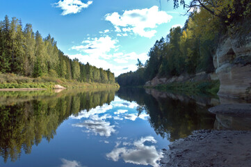 Obraz premium Clouds glide in the calm river