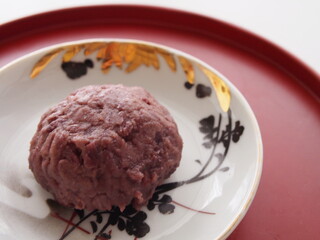 朱塗り盆の骨董皿にのったつぶ餡のおはぎ