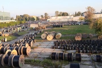 huge industrial reels of wires. Human-sized skeins with wires, industrial zone of a big city