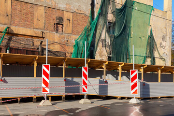 Construction repair fences on the sidewalk for the safety of pedestrians during the demolition of the old building