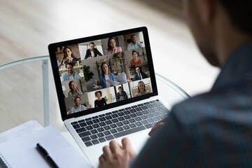 View over businessman shoulder group video call on laptop screen, diverse colleagues business...