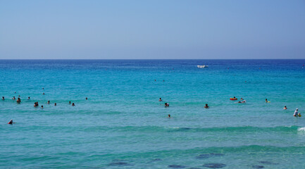 Fototapeta na wymiar beach sea blue sky people swimming in the distance