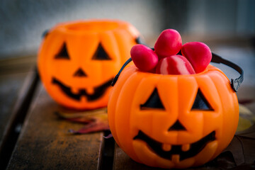 pumpkin-shaped bucket full of candies. party and halloween concept
