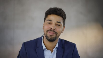 Smiling mixed race man looking at camera and listening. Head and shoulders shot of curly haired mid adult man. - Powered by Adobe