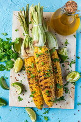 Roasted or Grilled Sweet Corn Cobs with Garlic, Coriander, Lime . Mexican Street Food. Top Down View