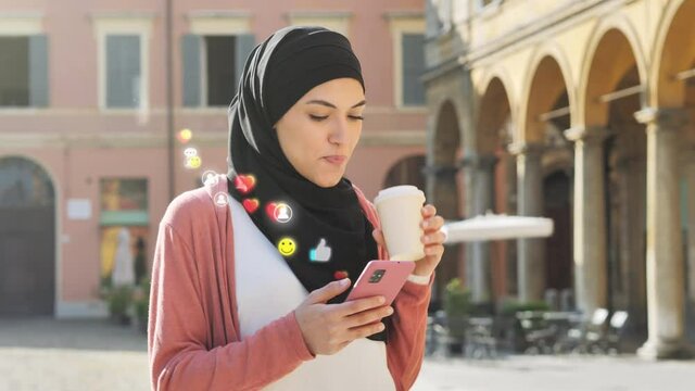 young woman influencer using mobile smart phone with 3d social media network icons coming out from smartphone,muslim arab girl walking in city center sending likes emoticons with cellphone